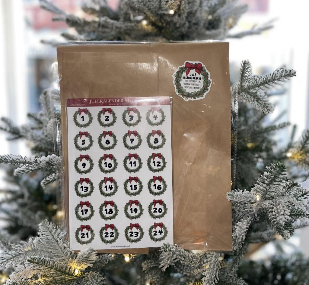 Kreativt kit - Easy Peasy Julekalender er et sæt med 24 gaveposer og stickers med alle dagene op til d. 24 december på. Fyld poserne, put en sticker på og hæng dem op på en snor eller lignende. Poserne er klassiske brune papirsposer og stickers er små, grønne julekranse med røde sløjer og datoen i midten.